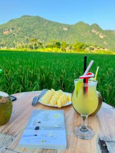 枚州县Green Homestay Mai Chau的餐桌,酒和一盘食物