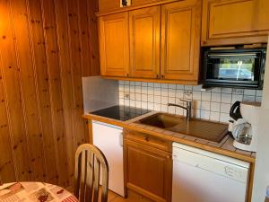 欧特吕斯Appartement Hauteluce, 2 pièces, 4 personnes - FR-1-293-355的厨房配有木制橱柜、水槽和桌子