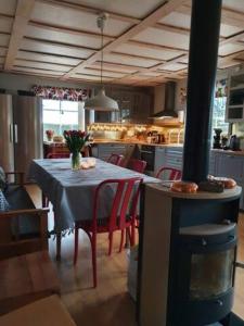 BäckeforsLillesjö stuguthyrning的一间带红色椅子和餐桌的厨房以及一间用餐室