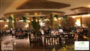 Qaryat al Bulushفندق بردى的用餐室配有桌椅和植物