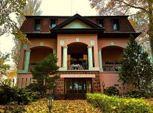 巴拉顿城堡Party Villa Holiday Rent Balatonfoldvar的粉红色的房子,上面设有阳台