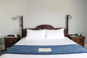 罗克波特Emerson Inn By The Sea的一张带木制床头板和2个床头柜的床