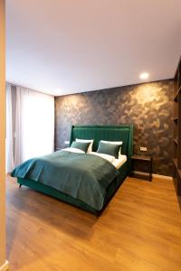 杜塞尔多夫B-Chill Düsseldorf的一间卧室设有绿色的床和石墙