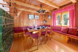GoreljekChalet Trzinka - Triglav National Park的一间带桌子和红色沙发的用餐室