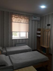 希瓦Hotel Allanazar Ota的一间卧室设有两张床和窗户。