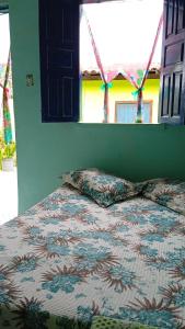 伦索伊斯Pousada Casa da Neuzita的卧室内的一张带被子和枕头的床