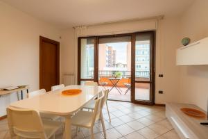福利尼奥MIZAR- Appartamento privato con parcheggio gratuito by Appartamenti Petrucci的厨房以及带白色桌椅的用餐室。