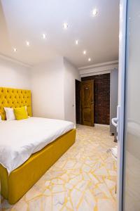 雅西Pensiunea Ewo的一间卧室设有一张大床和一个黄色床头板