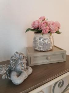 萨尔拉拉卡内达L appart d en face的粉红色玫瑰花瓶和桌子上的雕像