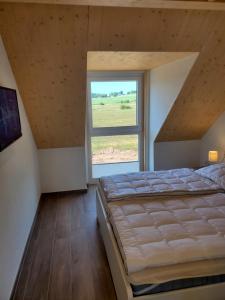 普吕姆Ferienhäuser Prüm的一间卧室设有一张大床和一个大窗户