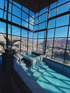拉巴斯阿提克斯酒店的一座大型游泳池,位于一座带窗户的建筑内