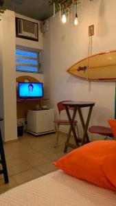 瓜鲁雅Pousada Chapéu de Sol的一间墙上设有桌子和冲浪板的房间