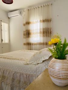乌姆苏克Djerba Dar BAYA的一间卧室配有床和花瓶