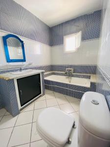 乌姆苏克Djerba Dar BAYA的一间带卫生间和浴缸的浴室以及一台电视。