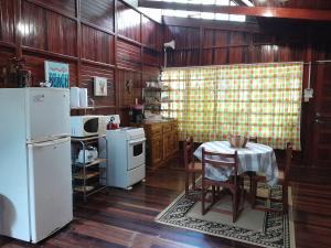 曼努埃尔安东尼奥Casas Guaney的厨房配有桌子和白色冰箱。
