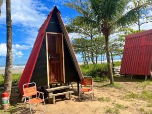 伯迪亚哥Chalé Jorai - pé na areia的黑色和红色的小帐篷,配有椅子和桌子