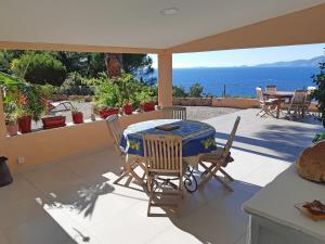 波尔蒂乔Les Terrasses du Pano - 76 m2 au calme - Jardin - Barbecue - Transats - Pleine vue mer - Wifi Fibre的一个带桌椅的庭院和大海