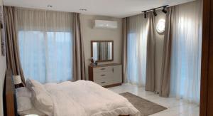 开罗بيت السمو的卧室配有白色的床和镜子
