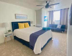 圣胡安KASA Royal Palms的一间卧室配有一张大床和一张蓝色的沙发