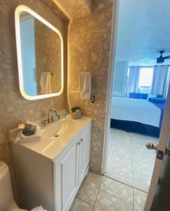 圣胡安KASA Royal Palms的一间带水槽和镜子的浴室以及一张床