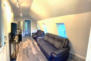 科布尔山Rustic 1-Bedroom farm style loft with fire pit的客厅配有真皮沙发和平面电视