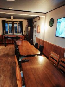 饭山市斑尾山山林小屋的餐厅设有木桌、椅子和平面电视。