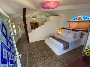 Barra Vieja班布达中心霍利斯提科旅馆的一间带一张床的卧室,位于带楼梯的房间