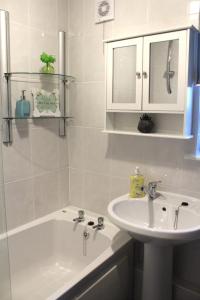 汉密尔顿PREMIER - Fleming Apartment的浴室配有盥洗盆、浴缸和盥洗盆