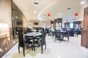 泗水凤蝶贝斯特韦斯特酒店的餐厅内带桌椅的用餐室