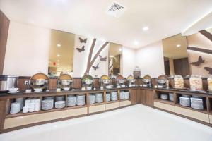 泗水凤蝶贝斯特韦斯特酒店的一间设有碗和盘子的柜台的房间