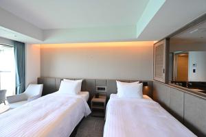 名户贝斯特韦斯特冲绳蔻琦酒店的酒店客房,设有两张床和镜子