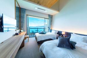 名户贝斯特韦斯特冲绳蔻琦酒店的酒店客房设有两张床和大窗户。