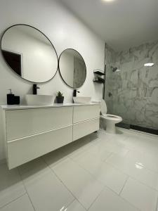 卡沃罗霍Casa Isabela En Cabo Rojo的一间带两个盥洗盆和大镜子的浴室