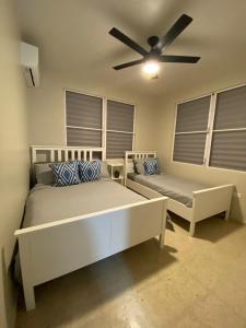卡沃罗霍Casa Isabela En Cabo Rojo的一间卧室配有两张床和吊扇