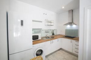 博尔穆霍斯Alijar Lux Bormujos的白色的厨房配有水槽和微波炉