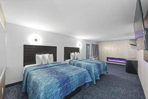 布朗克斯Hotel OPUS Bronx Near Bay Plaza Mall的酒店客房,配有两张带蓝色棉被的床