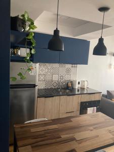马德普拉塔Único y Confortable Departamento zona Güemes (La Isla)的厨房配有蓝色橱柜和木桌