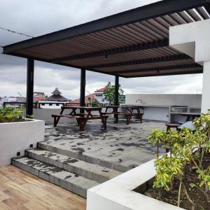 SeturanApartemen Strategis Yogyakarta的一个带长椅和野餐桌的庭院