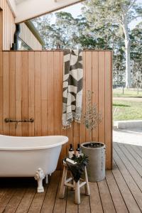 丹马克Upland Farm Luxury Cabins, Denmark Western Australia的木栅栏旁的甲板上设有浴缸