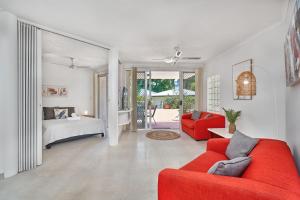 约克斯诺波Golden Sands Beachfront Resort的客厅配有红色的沙发和床。