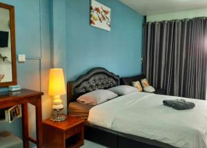 卡伦海滩Sala Bua Room的一间卧室配有一张床和一张带台灯的桌子