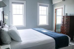 罗克波特Emerson Inn By The Sea的卧室配有一张白色大床和两个窗户