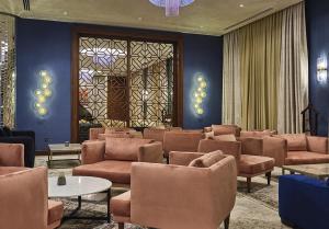 BasqalBasqal Resort & SPA的一间设有棕色桌椅和窗户的等候室