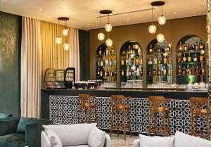 BasqalBasqal Resort & SPA的餐厅内的酒吧配有椅子和柜台