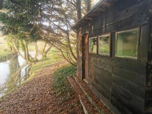 南安普敦Fisherman's Cabin on the banks of the River Meon的河边的建筑,有窗户