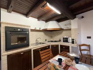 菲乌米奇诺La CASETTA di Antonietta的厨房配有桌子,墙上配有电视。