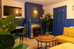 新港Stay in the heart of Isle of Wight in 2BDR apt的客厅设有蓝色的墙壁和壁炉