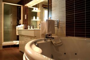 沙萨尼卡里布餐厅酒店的带浴缸、水槽和镜子的浴室