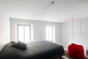 伊夫雷亚Appartamenti i Colori的一间卧室设有一张大床和两个窗户。