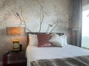 悉尼Sydney Cosmopolitan CBD Apartment的一间卧室配有一张带白色床单和花卉壁纸的床